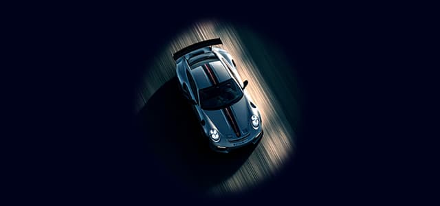 A sports car seen from above, driving fast on a road.