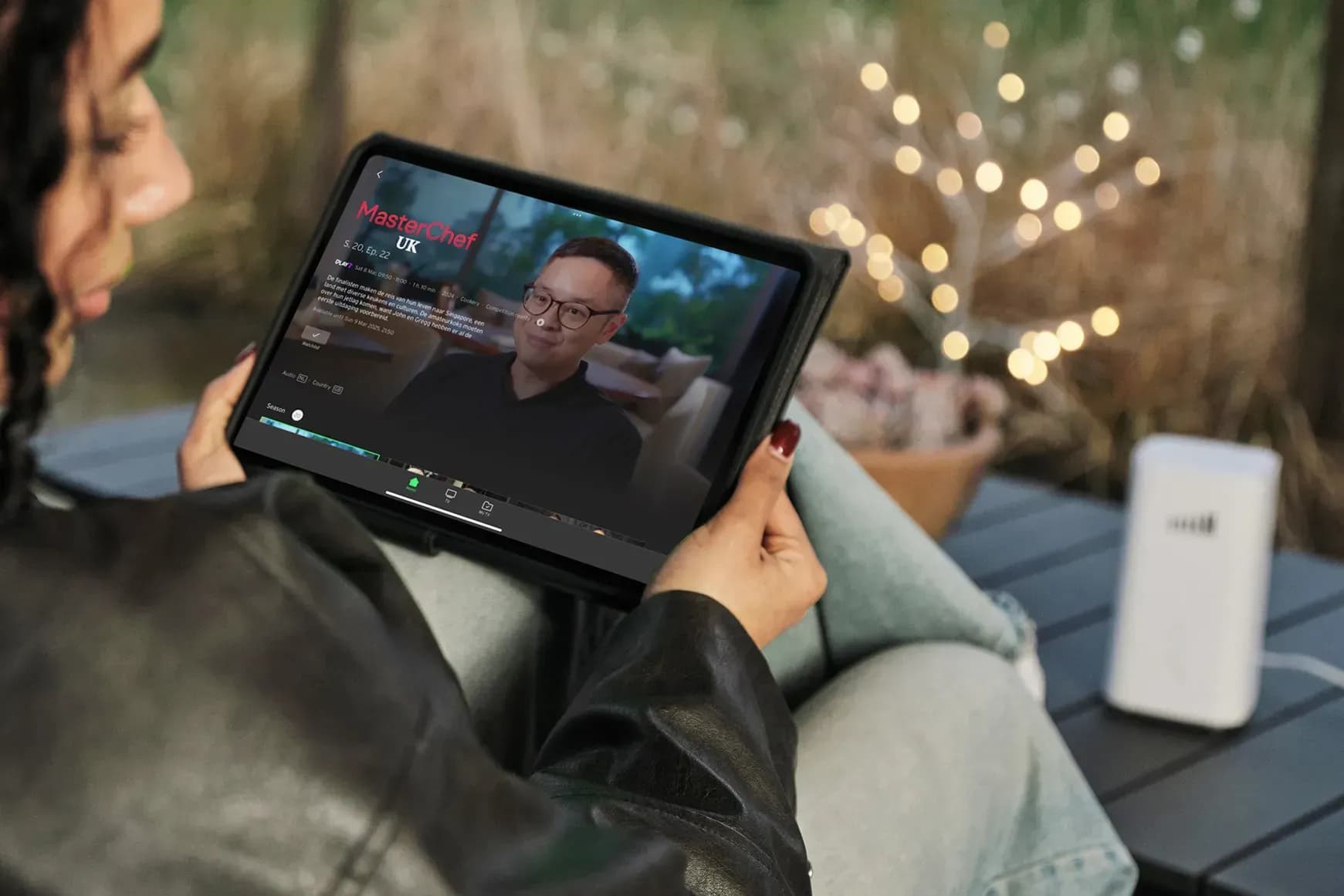 A person watching a TADAAM TV on an iPad.
