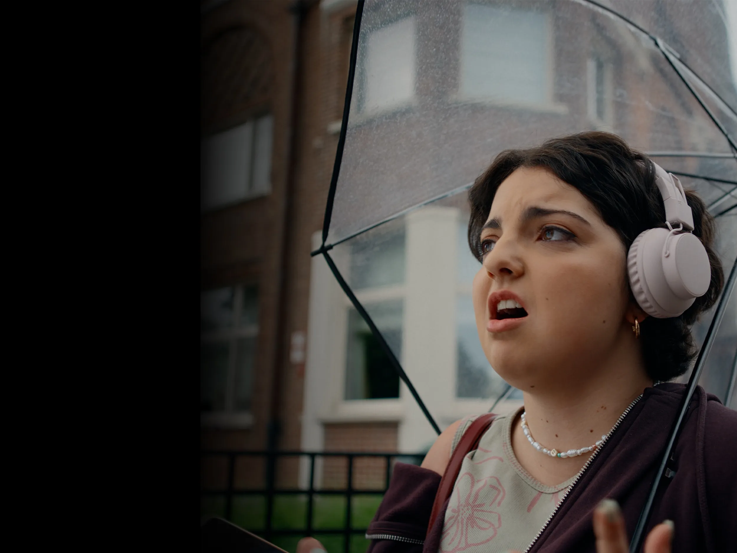 Girl with an umbrella looking frustrated.